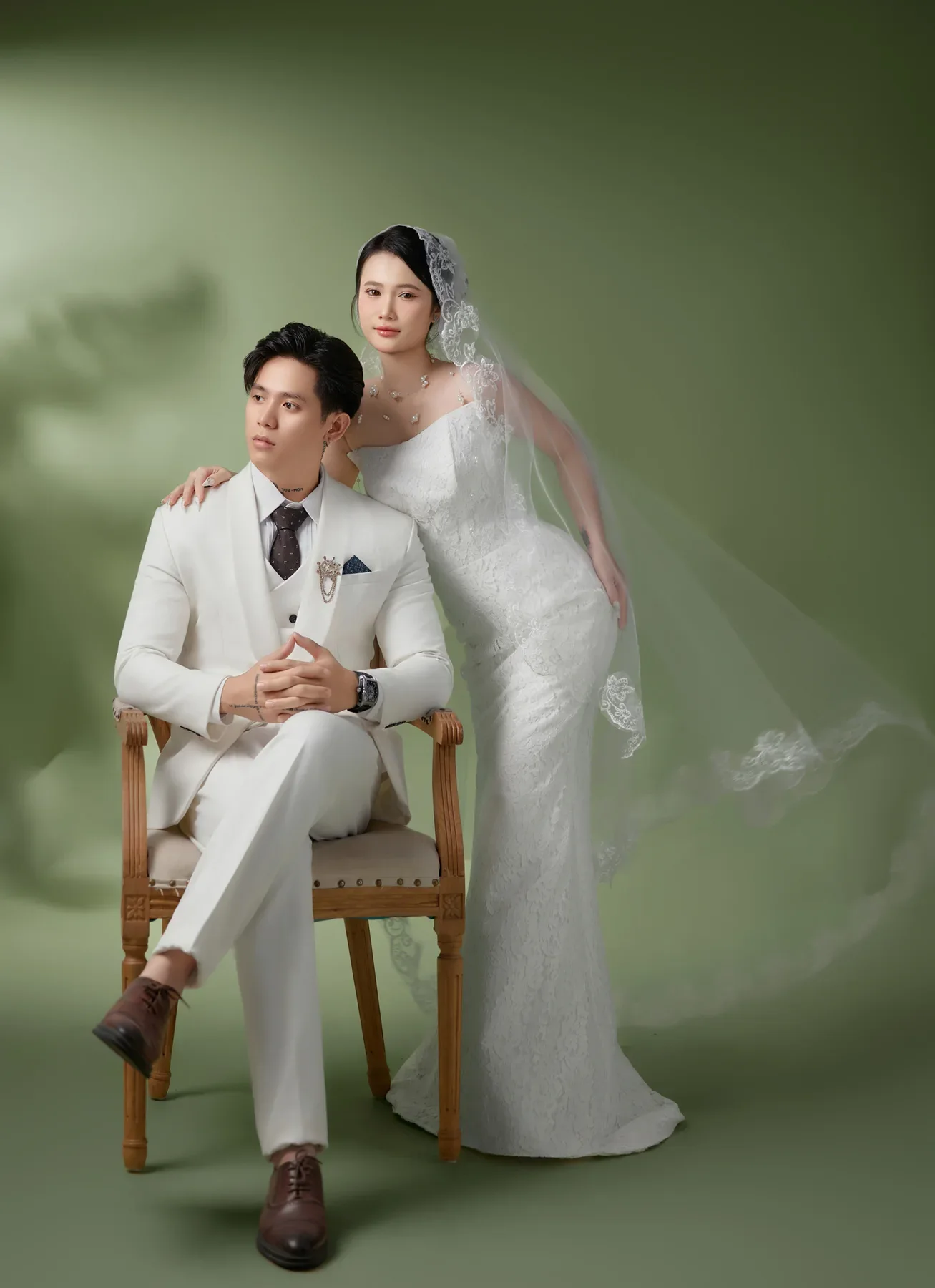 Chú rể ngồi cạnh cô dâu trong khung cảnh xanh